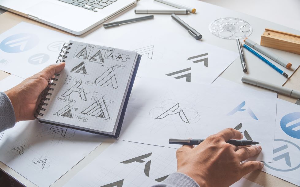 The Psychology of Logos & Graphics Image of a notebook with a sketch, featuring SEO & Reputation Management and highlighting the psychology of logos and graphics in building brand identity and audience perception.