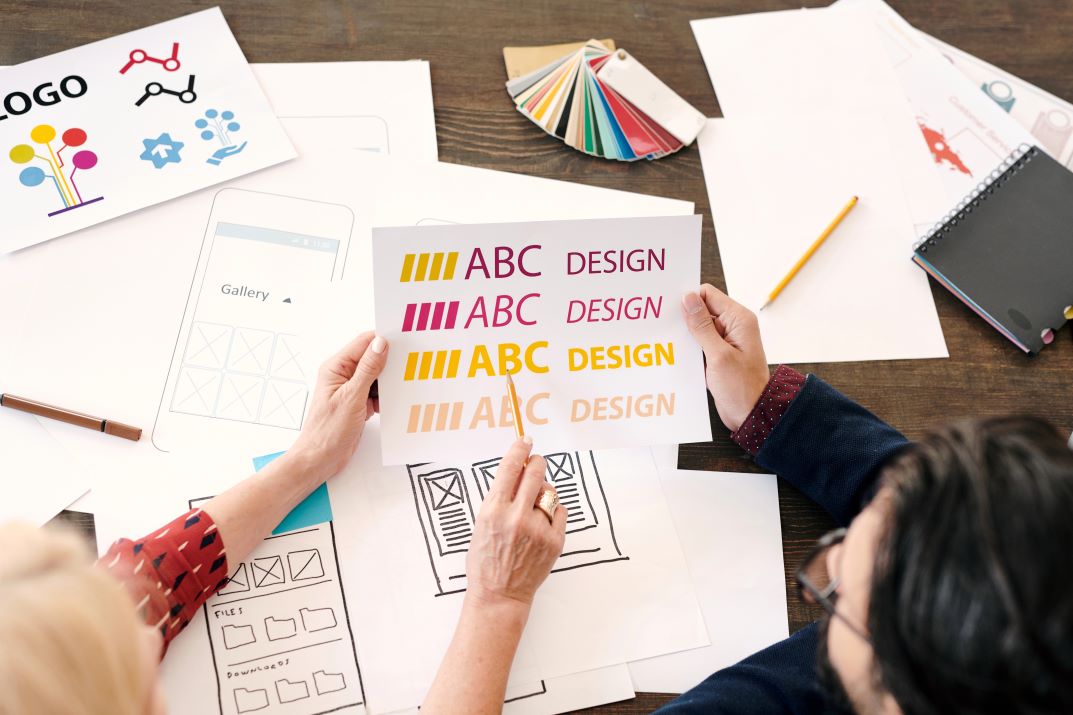 What Makes a Great Logo Image of hands holding a logo sketch, featuring SEO & Reputation Management and highlighting key elements of what makes a great logo for strong brand identity.